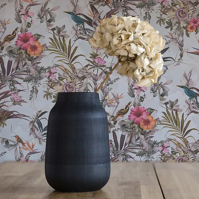 Tapete Tiere Maria M1-No.793 Vliestapete Weiß Grün Blumenoptik Dschungel -  - Schwarze strukturierte Vase mit Trockenblumen auf einem Holztisch vor tropischer Tapete.