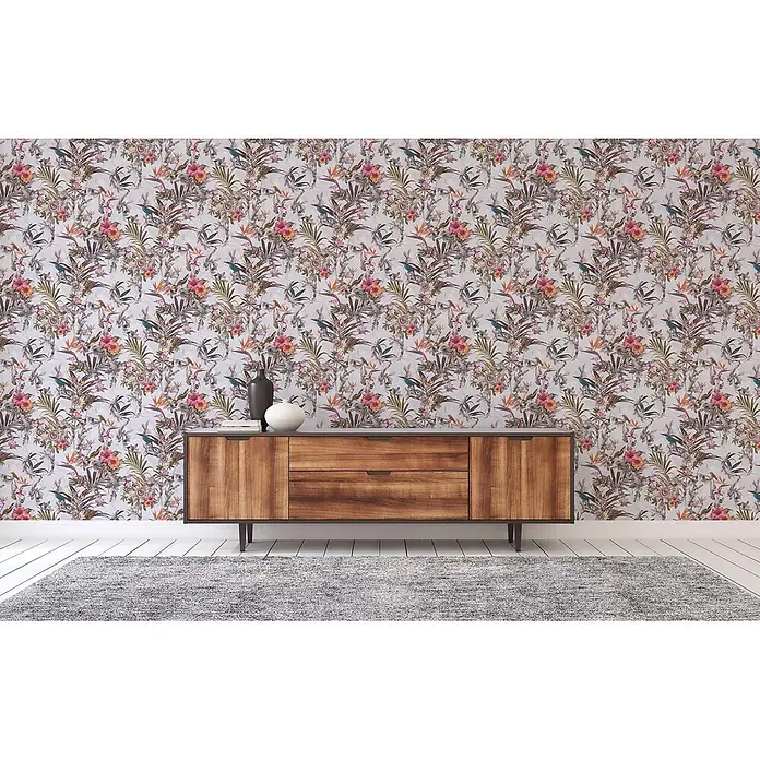 Tapete Tiere Maria M1-No.793 Vliestapete Weiß Grün Blumenoptik Dschungel -  - Tropische Blumentapete mit rosa und orangefarbenen Blüten, grünen Blättern und blauen Vögeln an einer Wand hinter einem Sideboard aus Holz.