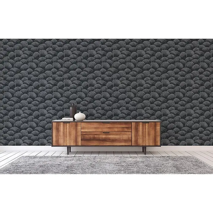 Tapete Dschungel Matilde M1-No.3873 Vliestapete Schwarz Dschungeltapete -  - Dunkelgraue Tapete mit wiederholtem hellgrauem Palmenblattmuster, die eine Wand hinter einem Holzschrank bedeckt.