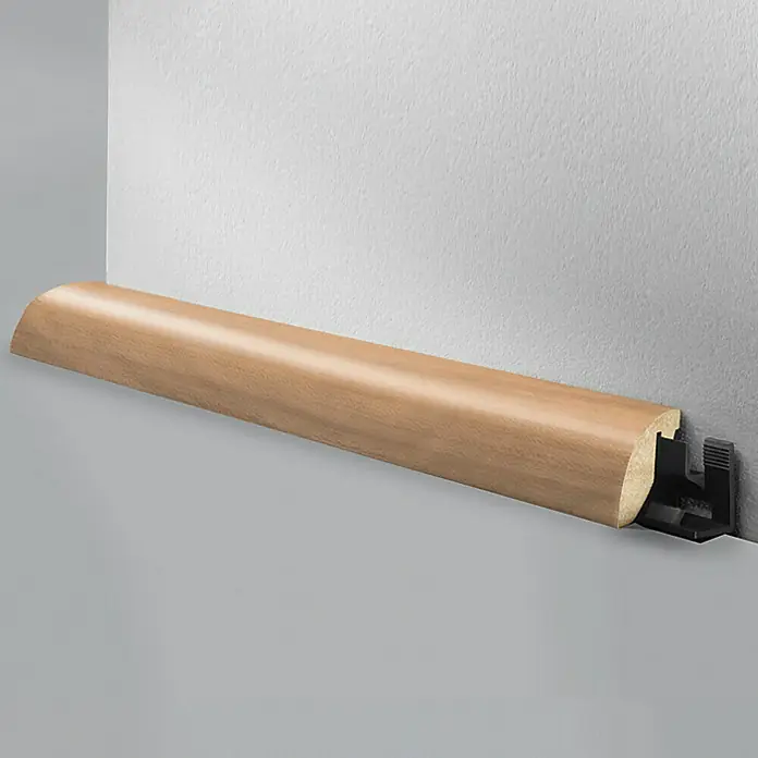 LOGOCLIC Viertelstab Apfelbaum - 260 cm x 23 mm x 29 mm, MDF - Holzsockelleiste mit abgerundeter Form und schwarzer Halterung an einer grauen Wand.