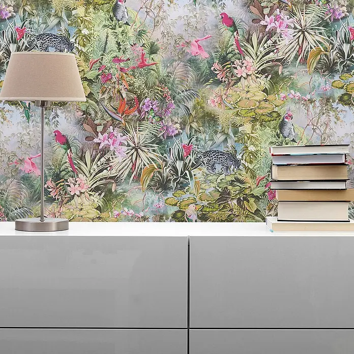 Tapete Dschungel Camilla M1-No.795 Vliestapete Grün Rosa Blumenoptik Natur -  - Lebendige Dschungel-Tapete mit Leoparden und Vögeln, hinter einer Lampe und Büchern auf einem weißen Schrank.