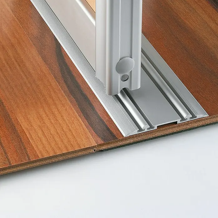 Room Plaza Easy Schienen-Bau-Set - Passend für: Room Plaza Easy Schiebetür-Bau-Sets, 2.488 mm, Silber - Nahaufnahme einer silbernen Türschiene auf einem Holzboden, die Funktionalität und modernes Design vereint.
