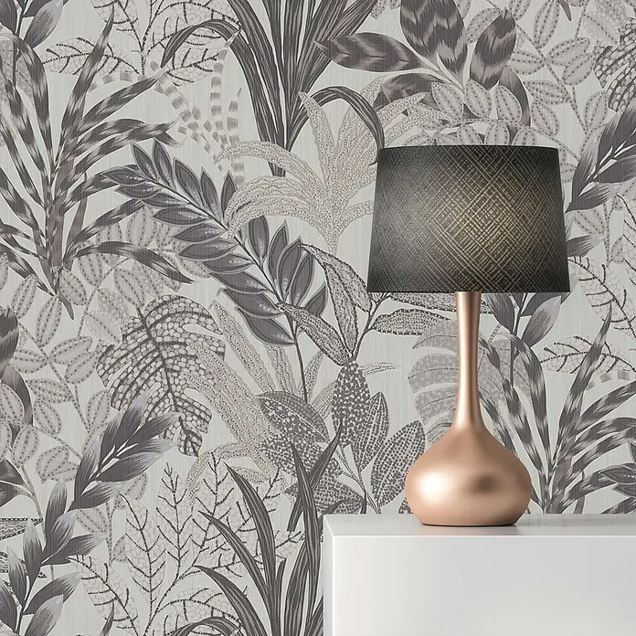 Tapete Dschungel Aleix M1-No.610 Vliestapete Grau Weiß Blumentapete Natur -  - Graue Tapete mit botanischem Blättermuster. Eine roséfarbene Lampe mit dunklem, texturiertem Schirm steht auf einem weißen Regal.