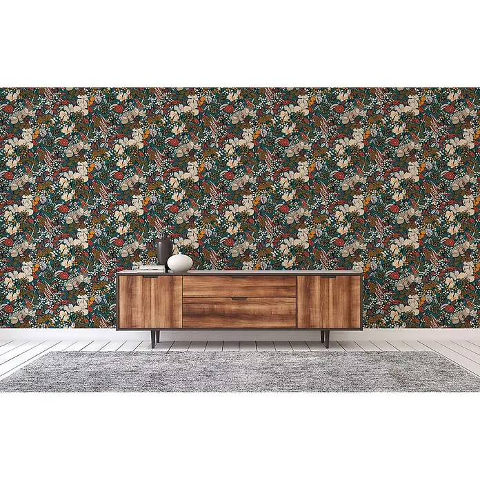 Tapete Dschungel Aleix M1-No.565 Vliestapete Bunt Gelb Natur Palmen -  - Sideboard aus Holz mit zwei Schubladen und Türen, vor bunter Blumentapete in einem Raum mit grauem Teppich.