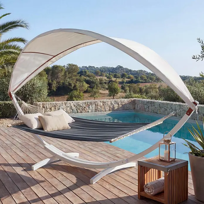 Mendler Hängematte HWC-J47 bis 200kg 420cm - weiß, grau -  - Weißer Hängemattenständer mit dunkelgrauer Liegefläche und Sonnenschutz, auf Holzterrasse am Pool für Entspannung im Freien.