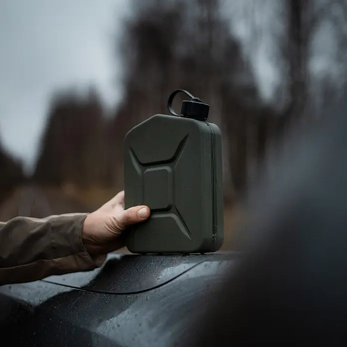 Oxid7 by BW Kraftstoffkanister Proper 2 l, Metall + Ausgießer, 2 Stk. -  - Dunkelgrüne Jerrycan-förmige Wasserflasche, von Hand gehalten, auf einem Auto.