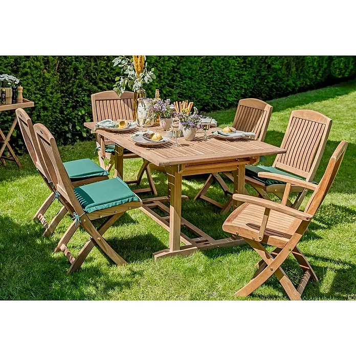 Sitzauflage Gartenstuhl grün dunkelgrün waschbar perfekte Verarbeitung -  - Garten-Essgruppe aus Naturholz: Tisch und sechs Klappstühle mit grünen Kissen, auf einem Rasen arrangiert.
