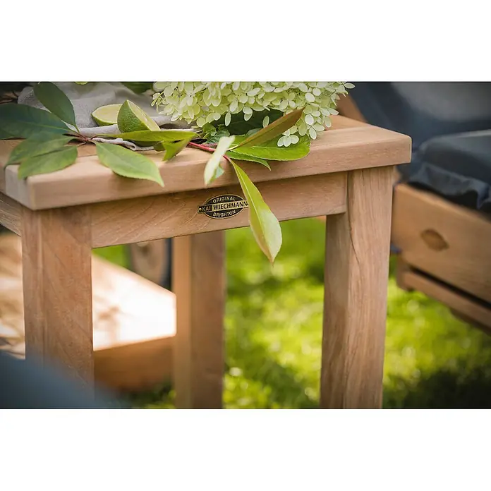 Teak Beistelltisch 40x40 cm edles Massivholz wetterfest perfekt verarbeitet -  - Holztisch mit "Kai Wiechmann Brighton" Plakette, mit Pflanzen dekoriert, im Außenbereich.