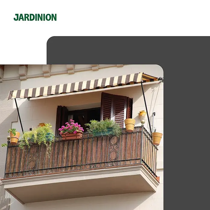 Jardinion Sichtschutz aus Weide 3m x 1,50m Braun Weidezaunmatte -  - Balkon mit gestreifter Markise, Pflanzgefäßen mit bunten Blumen und Grünpflanzen.