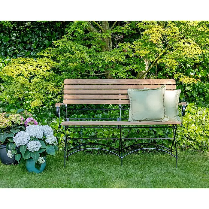 Teak Gartenbank Stahl und Teakholz 2-Sitzer Klappbank wetterfest edel -  - Gartenbank aus Holz mit schwarzem Metallgestell und zwei hellgrünen Kissen.