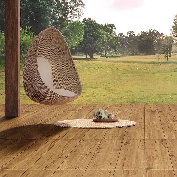 Feinsteinzeug in roher Nussbaumholzoptik 20x120, rutschhemmend -  - Geflochtener Rattan-Hänge-Eiersessel mit hellem Kissen auf einer Holzterrasse.