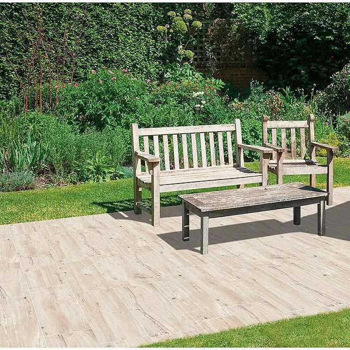 Feinsteinzeug in weißer Holzoptik 60x120, 20 mm, rutschhemmend -  - Helle Holzoptik-Terrassenfliesen bilden einen Sitzbereich im Freien in einem üppigen Garten.