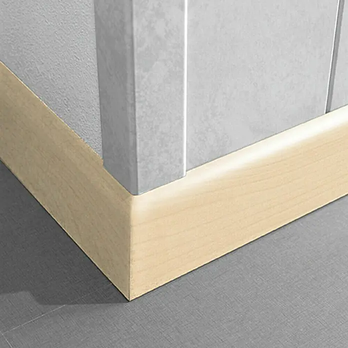 LOGOCLIC Sockelleiste K 58 Ahorn - 260 cm x 10 mm x 58 mm, MDF - Helle Holzfußleiste an einer grauen Wand mit grauem Boden, die das saubere und moderne Design des Raumes hervorhebt.
