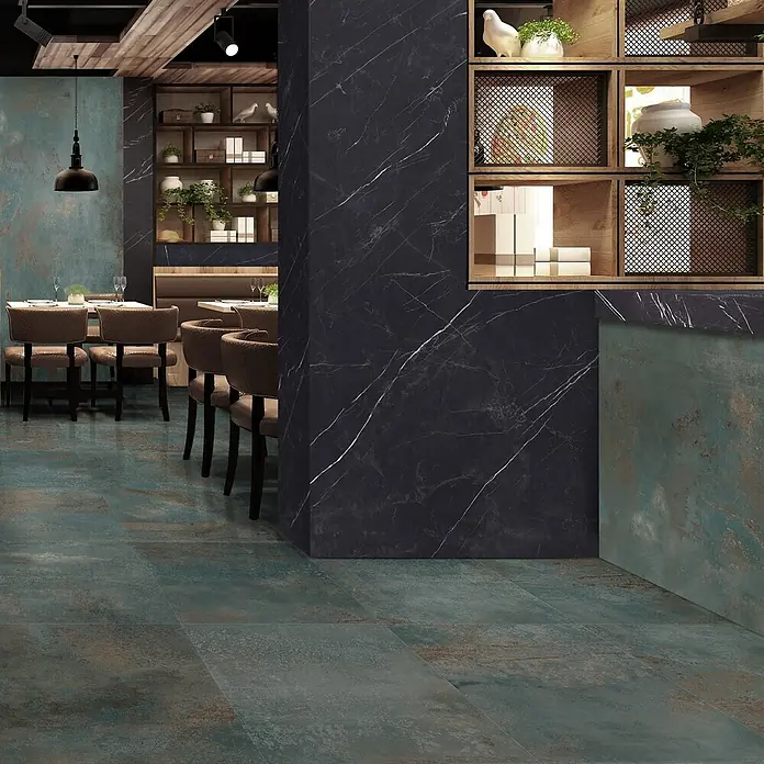 Feinsteinzeug in oxidierter grüner Metalloptik 60x120 - Ital. Fliesen -  - Oxidierte blaugrüne Boden- und Wandfliesen ergänzen eine dunkle Marmorsäule in einem modernen Restaurant.