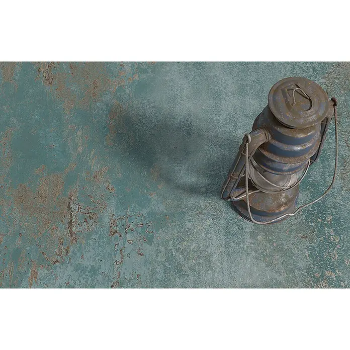 Feinsteinzeug in oxidierter grüner Metalloptik 60x120 - Ital. Fliesen -  - Eine rostige blaue Metalllaterne auf einer abgenutzten petrolfarbenen und braunen Oberfläche.