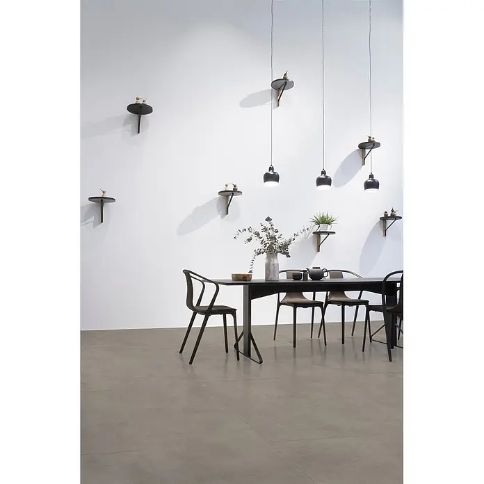 Feinsteinzeug in spachtelartiger dunkelgrauer Harzoptik 80x80 -  - Modernes Esszimmer mit schwarzer Essecke, eleganten Pendelleuchten und Wandregalen mit kleinen Vögeln.