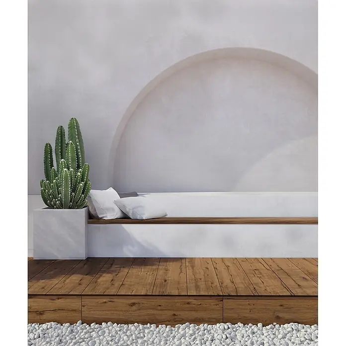 Feinsteinzeug in antiker Nussbaumholzoptik 30x120, rutschhemmend -  - Minimalistische Außenterrasse mit großem Kaktus in Betonkübel, eingebauter Bank mit Kissen und Holzdeck an weißem Kies.