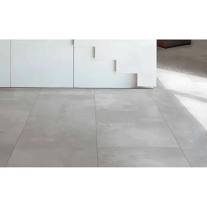 Feinsteinzeug in weißer Betonoptik 120x120 - Italienische Fliesen -  - Großformatige hellgraue Bodenfliesen mit dezenter Betonoptik, in einem modernen Innenraum verlegt.