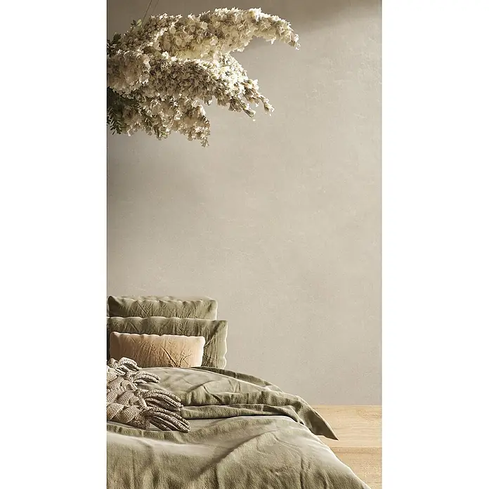 Feinsteinzeug in farbiger weißer Betonoptik 60x60 - Italienische Fliesen -  - Gemütliches Schlafzimmer mit einem Bett in salbeigrüner Samtbettwäsche und strukturierten Kissen, unter einem großen, aufwendigen hellen Blumendekor.
