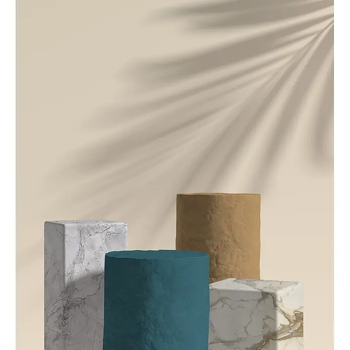 Feinsteinzeug in farbiger weißer Betonoptik 60x60 - Italienische Fliesen -  - Verschiedene Präsentationsständer aus Marmor und strukturiertem Stein, darunter graue und weiße Quader sowie teal- und braunfarbene Zylinder.
