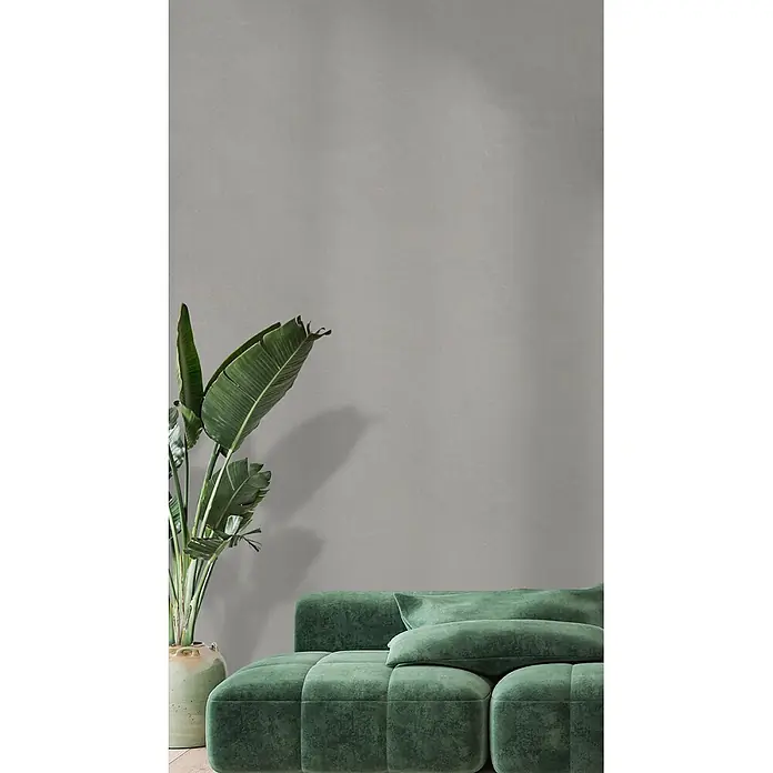 Feinsteinzeug in farbiger weißer Betonoptik 60x60 - Italienische Fliesen -  - Ein großes, plüschiges grünes Samt-Modulsofa mit Wurfkissen.
