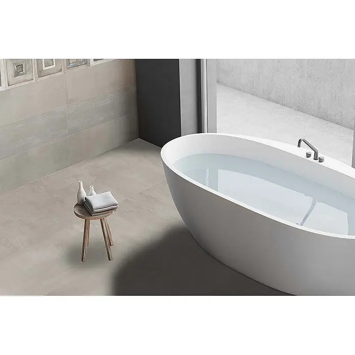 Feinsteinzeug in gebürsteter perlgrauer Betonoptik 60x60 - Ital. Fliesen -  - Hellgraue Fliesen in Betonoptik für Boden und Wände in einem minimalistischen Badezimmer mit freistehender Badewanne.