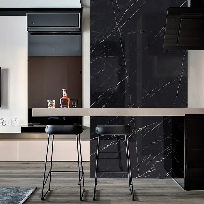 Feinsteinzeug in glänzender schwarzer Marquina-Marmoroptik 60x120 -  - Zwei schwarze moderne Barhocker mit schlanken Metallrahmen an einer Küchenzeile.