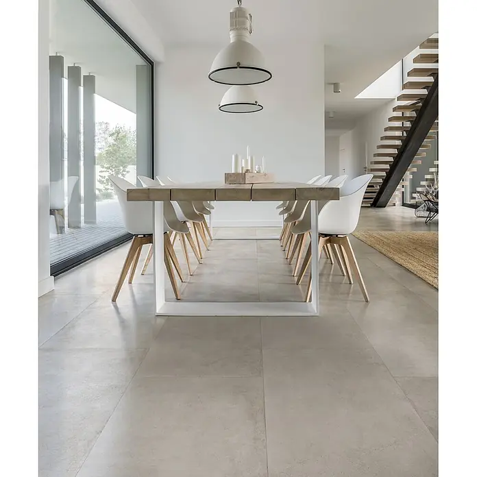 Feinsteinzeug in gewachster weißer Betonoptik 120x120 - Ital. Fliesen -  - Großformatige hellgraue matte Fliesen als eleganter Boden in einem modernen offenen Ess- und Wohnbereich.