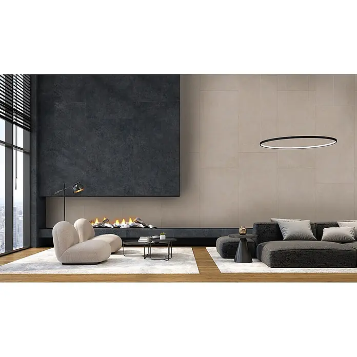 Feinsteinzeug in moderner schwarzer Betonoptik 80x80 - Italienische Fliesen -  - Ein modernes Wohnzimmer mit dunkelgrauem Ecksofa, beigefarbenen Sesseln und Kamin, akzentuiert durch eine schwarze ovale Pendelleuchte.