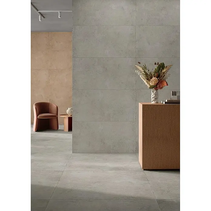 Feinsteinzeug in strukturierter mittelgrauer Betonoptik 80x80 -  - Großformatige Fliesen in Betonoptik, hellgrau, verkleiden Wände und Boden eines modernen Raumes.