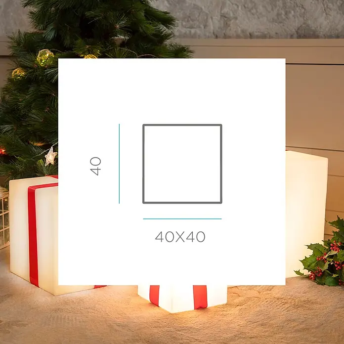 New Garden Figura LED navideña Cubo Gifty 40 Solar - 40 x 40 x 40 cm, Blanco, A batería, LED - Una caja decorativa blanca iluminada con cinta roja, con forma de regalo de Navidad, colocada sobre una alfombra junto a un árbol de Navidad. Dimensiones 40x40 cm.