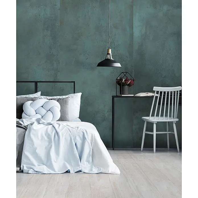 Feinsteinzeug in metallischer grüner Betonoptik 80x80 - Ital. Fliesen -  - Modernes Schlafzimmer mit tealfarbener Akzentwand, ausgestattet mit einem Bett mit hellblauer Bettwäsche, schwarzem Schreibtisch, weißem Stuhl und einer Hängelampe.