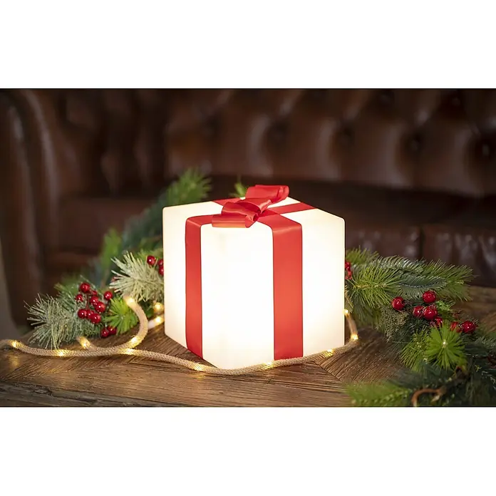 New Garden Figura LED navideña Cubo Gifty 40 Solar - 40 x 40 x 40 cm, Blanco, A batería, LED - Caja de regalo blanca iluminada con lazo rojo, adornada con guirnalda festiva y luces cálidas sobre madera, ideal para decoración navideña.
