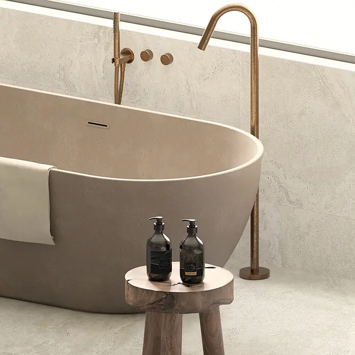 Design-Feinsteinzeug Weiß matt 120x120 - Italienische Fliesen -  - Eine moderne, freistehende Badewanne in warmem Beige mit passender antiker Messingarmatur und Duschkopf vor hellen Fliesen.