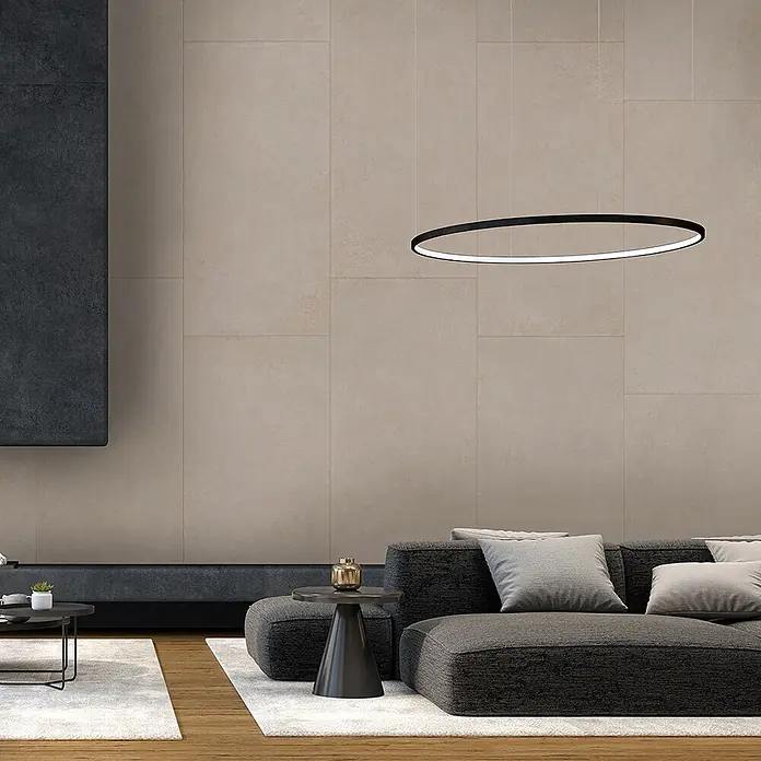 Feinsteinzeug in moderner elfenbeinfarbener Betonoptik 60x120 -  - Eine moderne, schwarze, ovale LED-Pendelleuchte, die über einem grauen Sofa in einem zeitgenössischen Wohnzimmer hängt.
