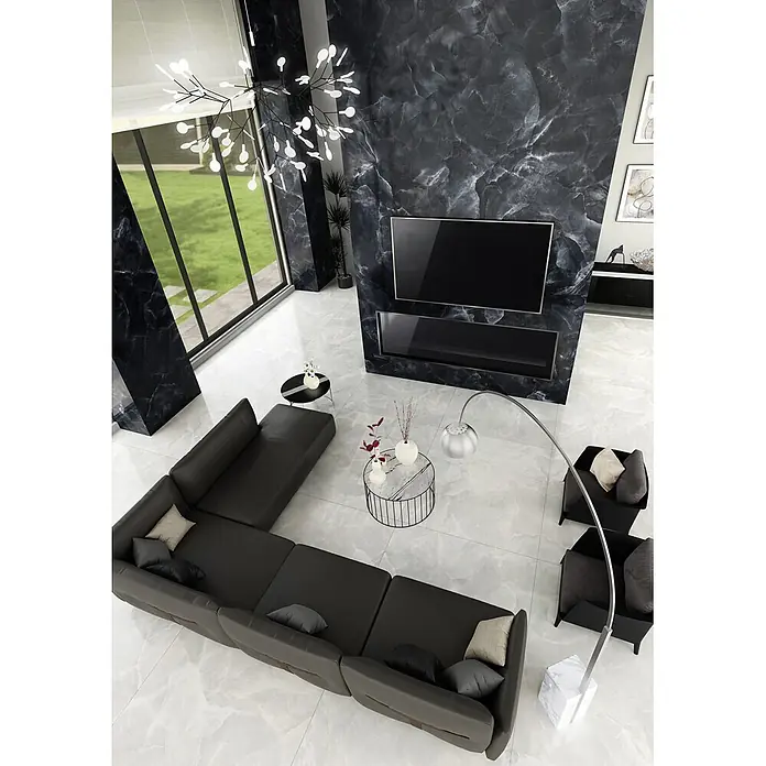 Feinsteinzeug in glänzender schwarzer Marmoroptik 30x60 - Ital. Fliesen -  - Großes dunkelgraues L-förmiges Ecksofa in einem geräumigen modernen Wohnzimmer mit hellem Boden und dunklen Marmorwänden.