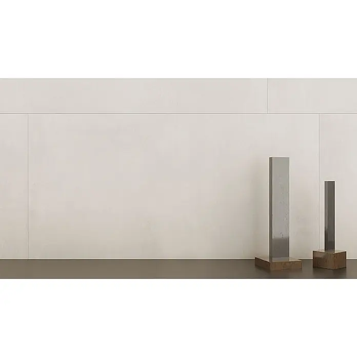 Feinsteinzeug in zeitgenössischer eisweißer Betonoptik 80x80 -  - Zwei schlanke, metallische Dekosäulen mit dunklen Holzsockeln stehen vor einer hellen Paneelwand.