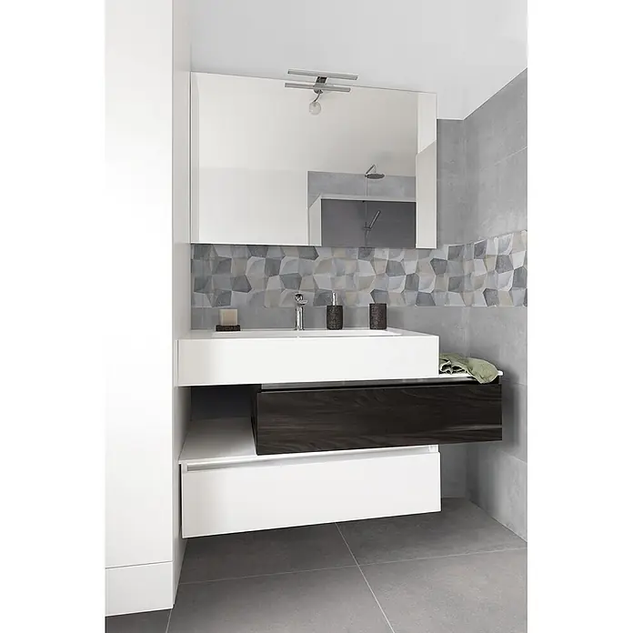 Feinsteinzeug in dunkelgrauer Harzoptik 30x60 - Italienische Fliesen -  - Moderne Badezimmermöbel mit weißem Waschbecken, dunklem Holzschublade und weißem Unterschrank, vor grauen und gemusterten Fliesen mit Spiegel.