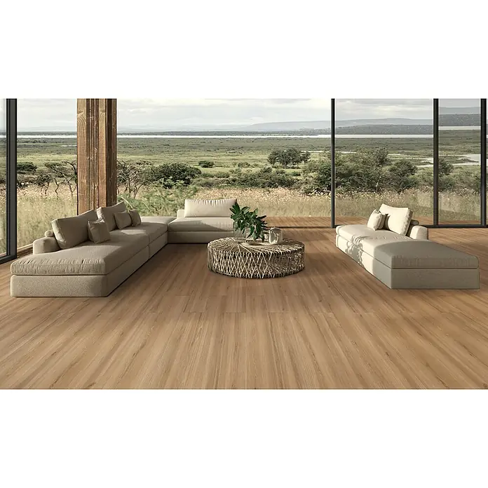 Feinsteinzeug in honigfarbener Holzoptik 20x120 - Italienische Fliesen -  - Helle Holzplankenböden in einem modernen Wohnzimmer mit großen Fenstern mit Blick auf eine Naturlandschaft.