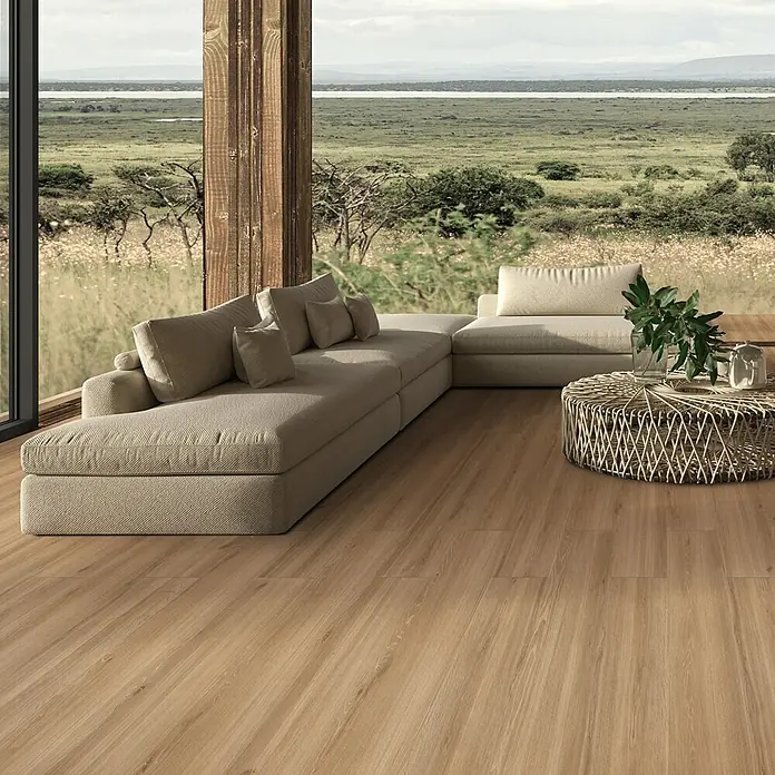 Feinsteinzeug in honigfarbener Holzoptik 20x120 - Italienische Fliesen -  - Heller Holzoptik-Dielenboden in einem modernen Wohnzimmer mit großem Ecksofa und Korbsalontisch.