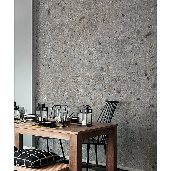 Feinsteinzeug in matter hellgrauer Steinoptik 120x120 - Ital. Fliesen -  - Graue Terrazzo-Optik Wandfliesen mit mehrfarbigen Aggregaten an einer Wand im Essbereich.