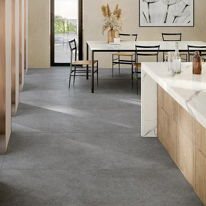 Design-Feinsteinzeug dunkelgrauer matter 120x120 - Italienische Fliesen -  - Graue gesprenkelte Bodenfliesen in einem modernen offenen Wohnraum mit Essbereich und Kücheninsel.