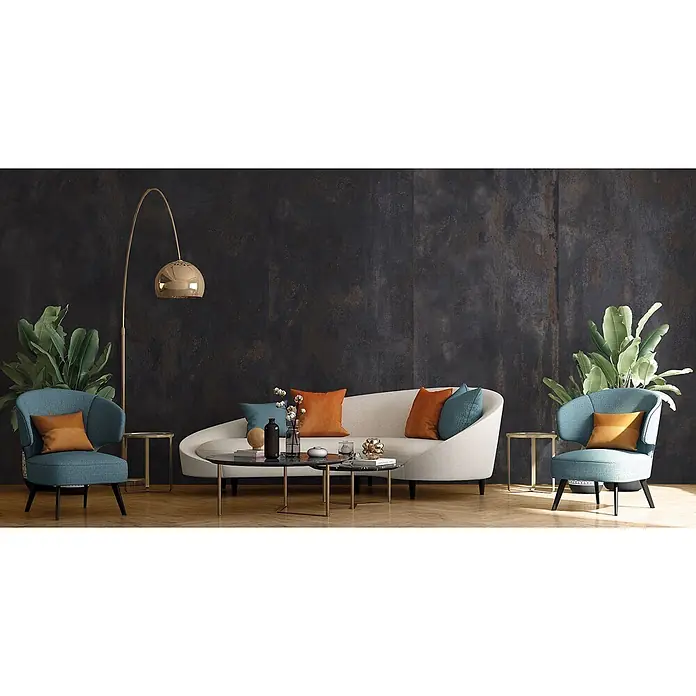Feinsteinzeug in oxidierter schwarzer Metalloptik 80x80 - Ital. Fliesen -  - Modernes Wohnzimmer mit hellem, geschwungenem Sofa, orange-türkisen Kissen, blauen Sesseln und Goldakzenten.