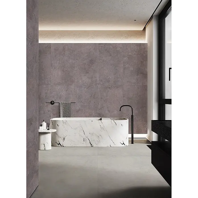 Feinsteinzeug in grauer Betonoptik 120x120 - Italienische Fliesen -  - Modernes Badezimmer mit einer freistehenden Badewanne aus weißem Marmor, dunkelgrauen Wandfliesen und einer schwarzen Standarmatur.