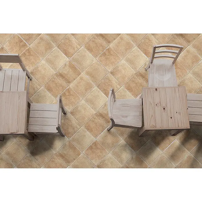 Feinsteinzeug in natürlicher 04 Terrakottaoptik 30x30 - Ital. Fliesen -  - Braune und beige gemusterte Bodenfliesen diagonal verlegt, mit hellen Holztischen und Stühlen darauf.