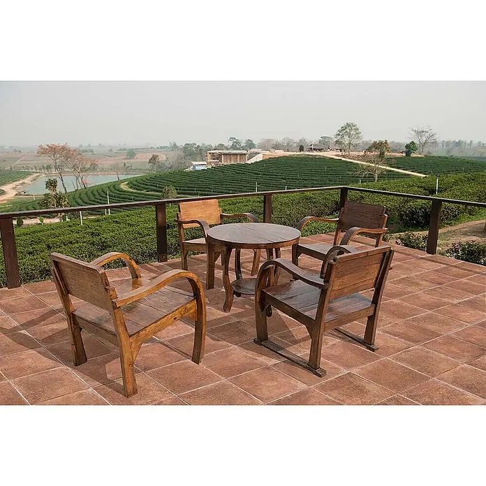 Feinsteinzeug in Terrakotta natürlicher Terrakottaoptik 30x30 -  - Dunkler Holztisch und vier Stühle auf einer gefliesten Terrasse mit Blick auf eine Teeplantage.