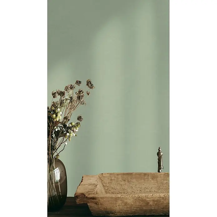 Feinsteinzeug in farbiger grüner pastellfarbener Betonoptik 60x60 -  - Getrocknete Blumen in einer Glasvase, eine rustikale Holzschale und eine Pfeffermühle auf einer Tischfläche arrangiert.