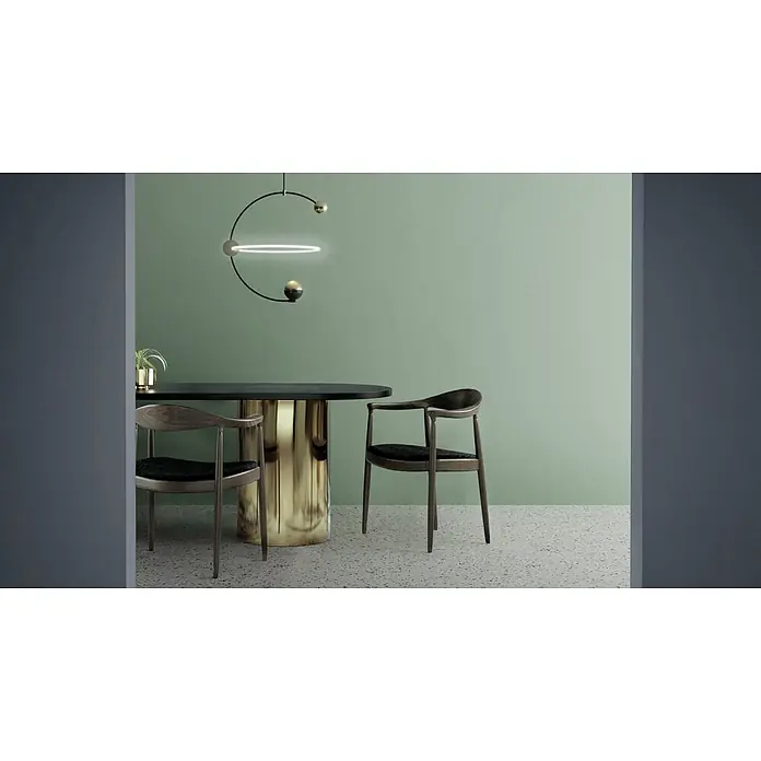 Feinsteinzeug in farbiger grüner pastellfarbener Betonoptik 60x60 -  - Moderner Essbereich mit schwarzem Tisch, goldenem Sockel, dunklen Holzstühlen und einer markanten Pendelleuchte mit leuchtendem Ring.