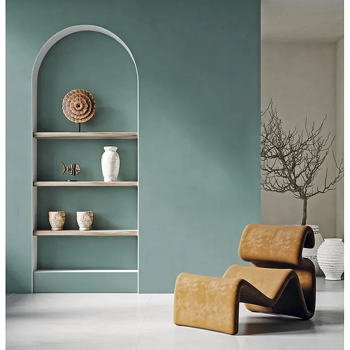 Feinsteinzeug in farbiger grüner pastellfarbener Betonoptik 60x60 -  - Brauner, wellenförmiger Loungesessel mit einzigartigem Design in einem minimalistischen Wohnraum neben einem Regal.