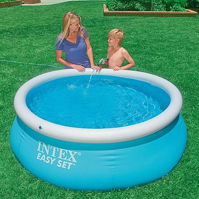 Intex Piscina Quick-Up Easy Set - Ø x Al: 183 x 51 cm, Azul, 886 l - Una piscina Intex Easy Set está siendo llenada con una manguera de agua mientras una mujer y un niño están cerca.